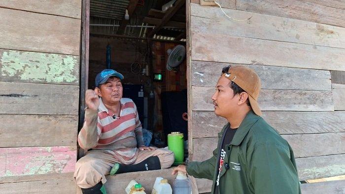 PETANI NILAM - Wartawan Serambi Indonesia, Maulidi Alfata berbincang dengan Junaidi, petani nilam, yang menjadi korban bencana banjir, memperlihatkan tiga jeriken minyak nilam yang berhasil ia selamatkan dalam banjir, sementara katel dan lahan nilamnya rusak diterjang banjir di Aceh Timur, Sabtu (11/4/2026).