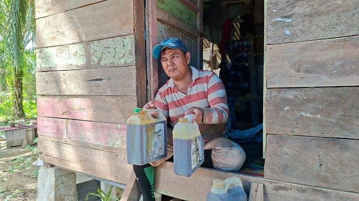 PETANI NILAM - Junaidi petani nilam, yang menjadi korban bencana banjir, memperlihatkan tiga jeriken minyak nilam yang berhasil ia selamatkan dalam banjir, sementara katel dan lahan nilamnya rusak diterjang banjir di Aceh Timur, Sabtu (11/4/2026).