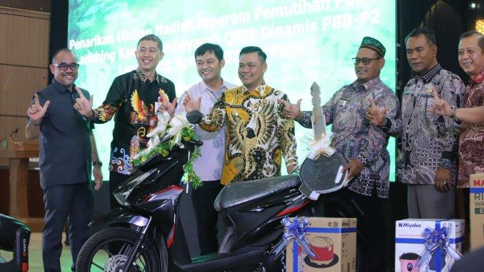 Wakil Bupati Pidie, Alzaizi, menyerahkan hadiah satu unit sepeda motor Beat saat penarikan pembayaran PBB-P2, di Gedung PCC Sigli, Kamis (5/2/2026).