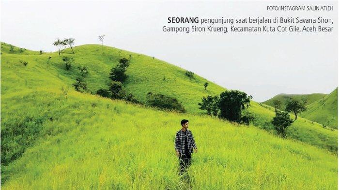 Seorang pengunjung saat berjalan di Bukit Savana Siron, Gampong Siron Krueng, Kecamatan Kuta Cot Glie, Aceh Besar