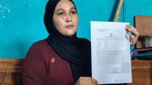 Korban-Mokarromah-saat-menunjukkan-bukti-laporan-polisi.jpg