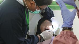 Seorang-dokter-gigi-FKG-USK-tengah-memeriksa-gigi-anak-pada-kegiatan-Aksi-Kaninus.jpg