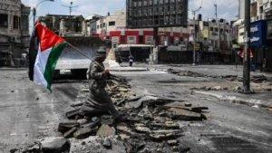 Seorang-warga-Palestina-memegang-bendera-Palestina-saat-berjalan-di-jalanan-Jenin-Tepi-Barat.jpg
