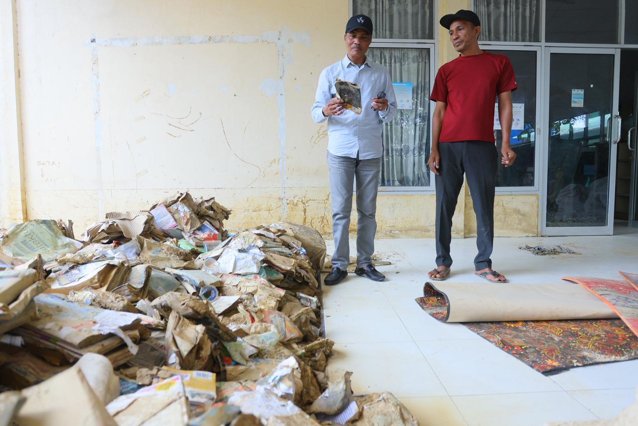 Kepala DPKA, Dr Syaridin, saat meninjau Gedung Dinas Perpustakaan dan Kearsipan Kota Langsa dan menemukan banyak buku dan arsip yang basah dan tertimbun lumpur, Minggu (21/12/2025).