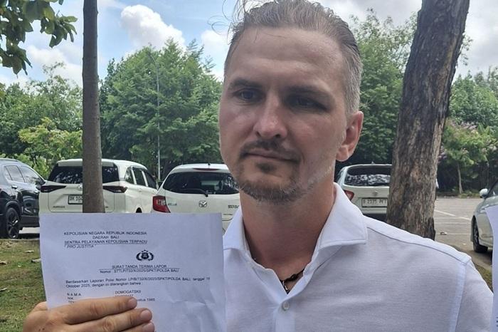 Sergeii-Domogastkii-40-WNA-asal-Rusia-saat-menunjukan-surat-laporan-polisi.jpg