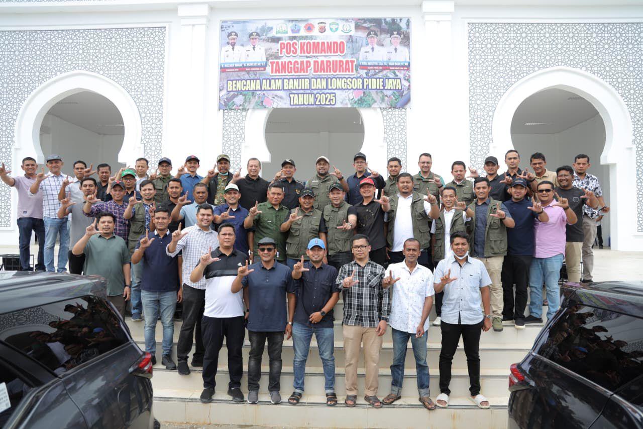Dirut Bank Aceh Fadhil Ilyas berfoto bersama Bupati Pidie Jaya Syibral Malasyi dan Wakil Bupati Hasan Basri beserta jajaran Bank Aceh saat penyerahan bantuan Bank Aceh untuk korban bencana hidrometeorologi di Posko Utama Penanganan Banjir Pidie Jaya, Meureudu, Sabtu (13/12/2025).