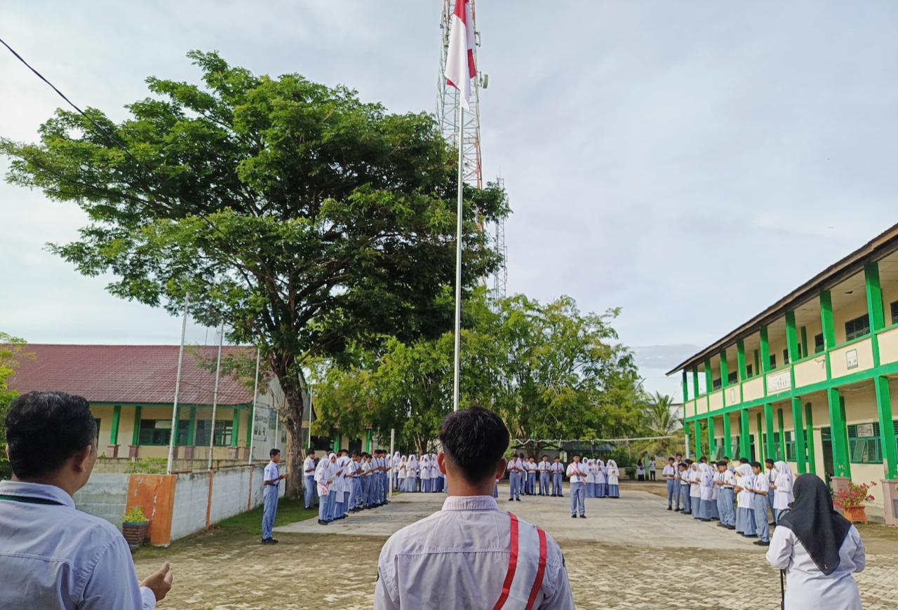 Suasana khidmat upacara bendera di MAN 6 Aceh Besar, Senin (4/5/2026). Para siswa berdiri dalam formasi di lapangan saat Sang Merah Putih dikibarkan oleh pasukan Paskibra, menjadi momen refleksi sebelum amanat pembina upacara yang menyoroti bahaya candu gadget di kalangan pelajar.