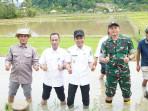 Kadis-Pertanian-Dailami-mendampingi-Wabup-Aceh-Jaya-saat-melakukan-penanaman-serentak-padi.jpg