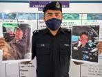 Kepala-Polisi-Distrik-Mersing-Cyril-Edward-menunjukkan-dua-foto-penyelam-yang-ditemukan-hidup.jpg
