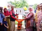 Rektor-UBBG-Prof-Dr-Lili-Kasmini-MSi-menyerahkan-peralatan-Hibah-kepada-masyarakat-Desa-Baet.jpg