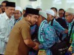 pj-bupati-aceh-besar-menyalami-hamzah-calon-haji-jch-kabupaten-aceh-besar.jpg