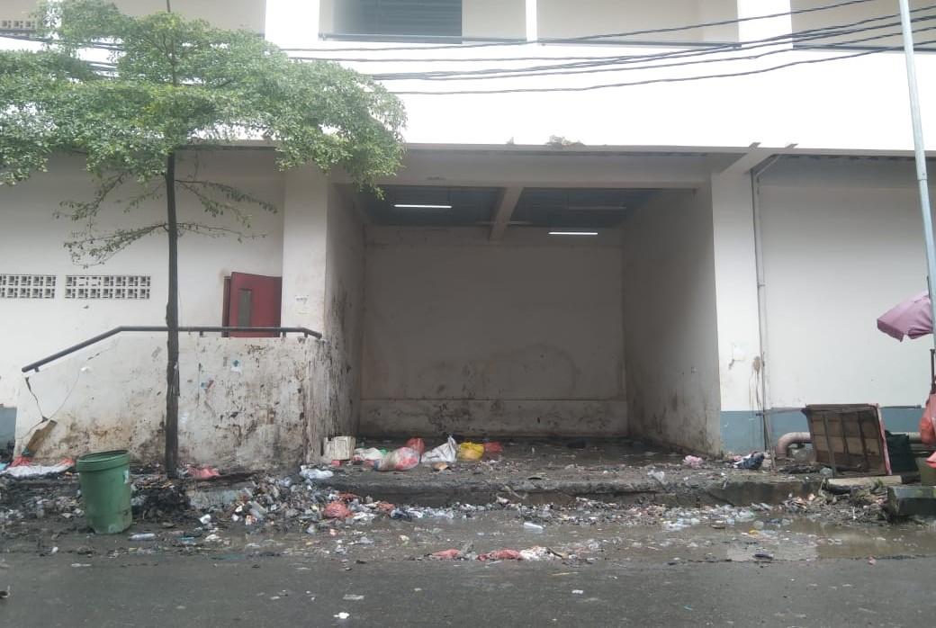 Petugas kebersihan membersihkan sampah di jalanan kota Bandung yang ramai setelah perayaan malam tahun baru, dengan tumpukan sampah yang terlihat di beberapa tempat, langit malam yang gelap dengan lampu kota.