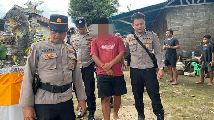 DIAMANKAN - Komang Agus saat diamankan anggota Polsek Seririt pasca menebas Kadek Sastrawan, Kamis (19/3/2026).