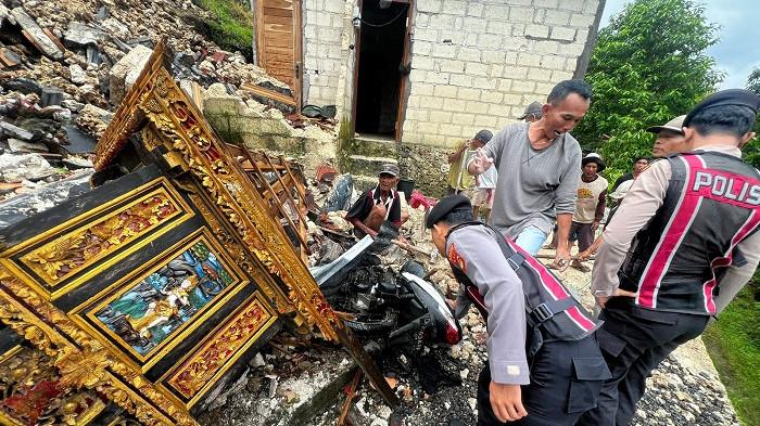 LONGSOR - Musibah longsor di Banjar Buah, Desa Kutampi, Klungkung, Selasa (25/2/2026). Tebing yang longsor hampir menimpa Kadek Dwi yang hendak memindahkan sepeda motor.