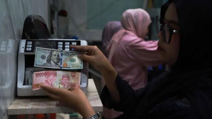NILAI TUKAR RUPIAH - Petugas merapikan tumpukan mata uang dolar di Kantor Cabang Muamalat Tower, Jakarta, Kamis (5/3) kemarin.  Nilai tukar rupiah di level Rp 17.529 per dolar AS pada Selasa (12/5).