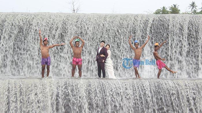 Pemuda Banjar Sukaduka membantu wisatawan asing melakukan sesi foto prewedding di Tukad Unda, Klungkung, Bali, Senin (25/3/2019)