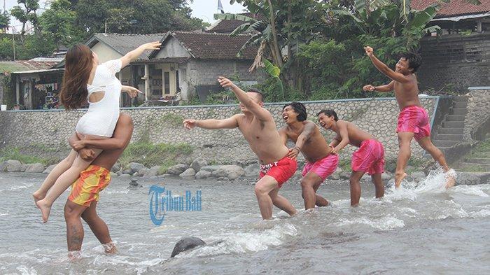 pemuda dari berbagai usia membantu wisatawan asing yang tengah melakukan foto prewedding di Wisata Tukad Unda, Klungkung, Bali, Senin (25/3/2019). 