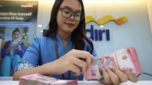 Karyawan-bank-menunjukkan-uang-pecahan-rupiah.jpg