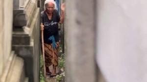 Seorang-warga-mencoba-melintas-jalan-sempit-di-samping-tembok-pembatas.jpg