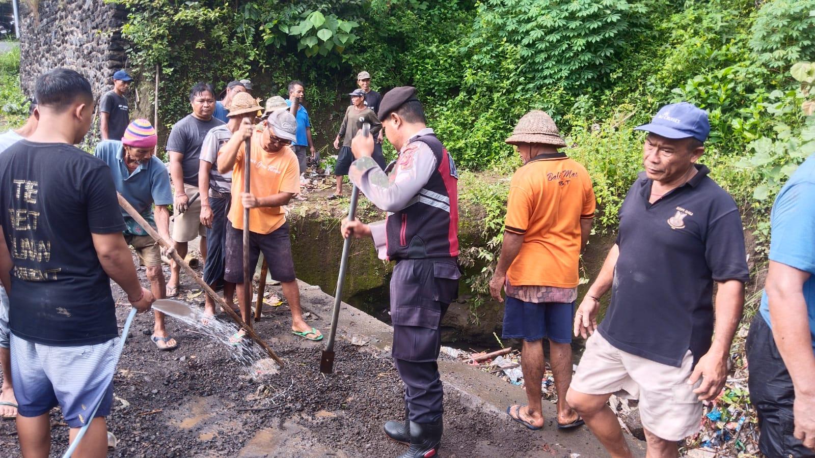 Gotong royong: Masyarakat bersama aparat gotong royong bersihkan material longsor di Desa Saba, Kecamatan Blahbatuh, Gianyar, Bali, Selasa 16 Desember 2025. Pasca Hujan Deras, Masyarakat dan Polisi Gotong Royong Bersihkan Material Longsor Di Saba Bali