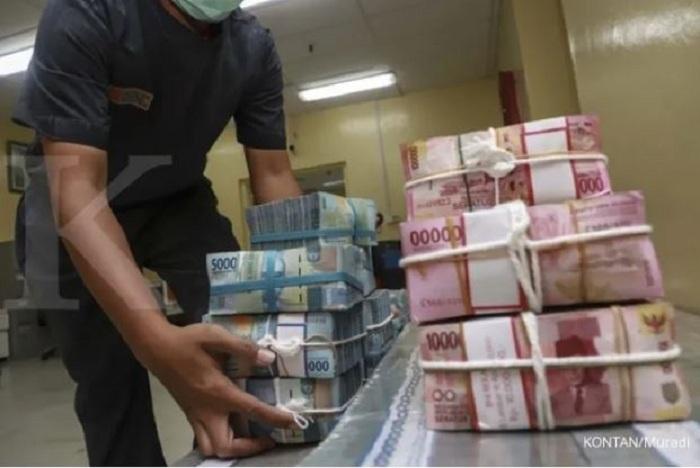 MENATA-seorang-karyawan-bank-menata-uang-rupiah-di-bank-yang-ada-di-Jakarta.jpg