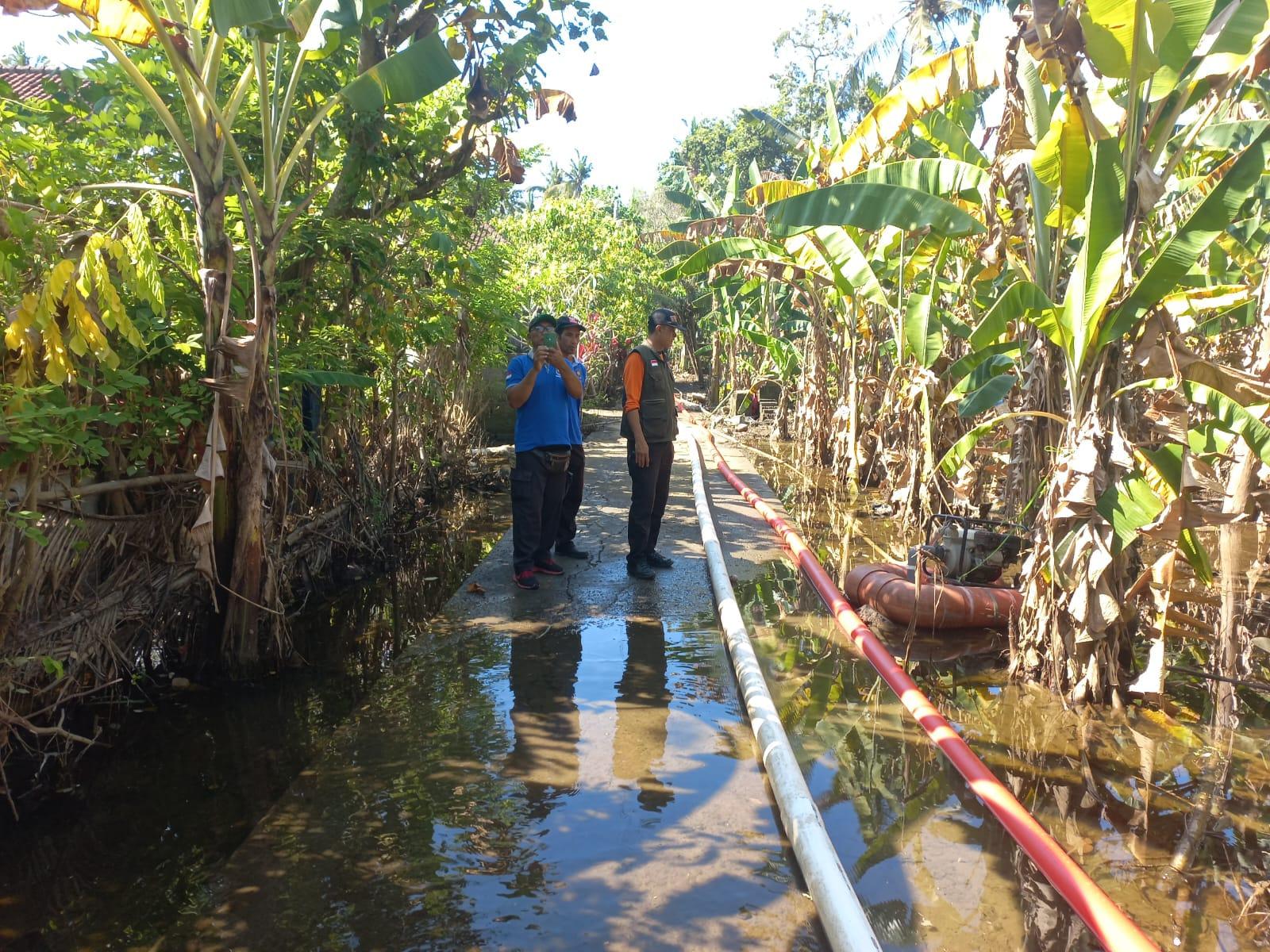 Petugas-melakukan-penyedotan-air-banjir-yang-menggenang-Banjar-Dinas-Tengading.jpg