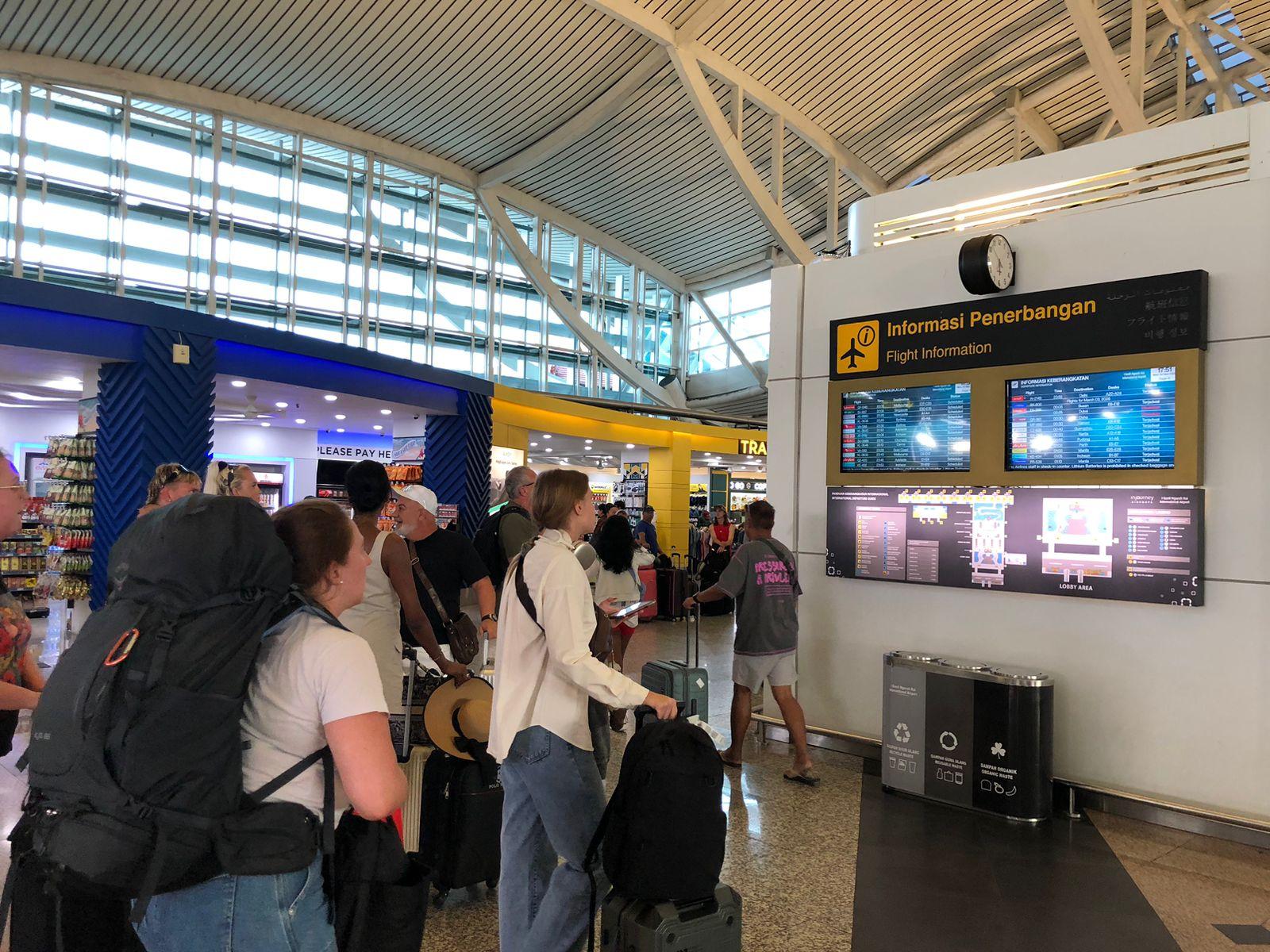 Sejumlah-wisatawan-asing-tampak-memantau-papan-informasi-keberangkatan-di-Bandara-Ngurah.jpg