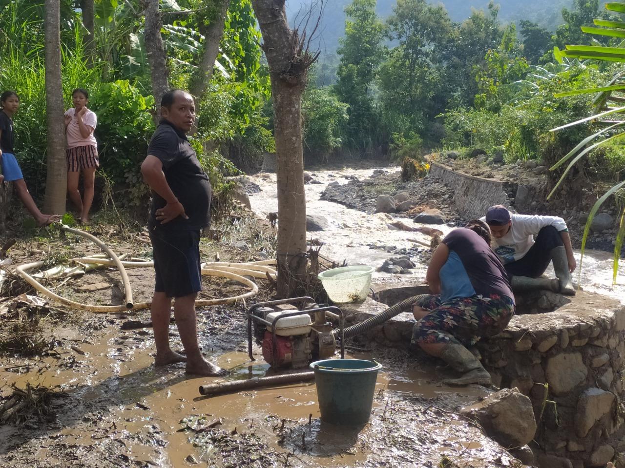 Warga-Desa-Banyupoh-saat-memperbaiki-pipa-air-bersih-yang-putus-akibat-diterjang-banjir.jpg