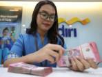 Karyawan-bank-menunjukkan-uang-pecahan-rupiah.jpg