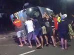 Petugas-bersama-warga-saat-membantu-evakuasi-minibus-terguling-di-Jalan-Sudirman.jpg