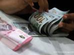Seorang-pegawai-money-changer-menghitung-uang-pecahan-dolar-dan-rupiah.jpg