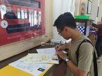 salah-satu-pemohon-pembuatan-skck-terlihat-mengisi-berkas.jpg