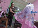 yuli-menjahit-mukena-di-rumah-produksinya-kawasan-taman-pancing-denpasar-selasa-27-april-2021.jpg