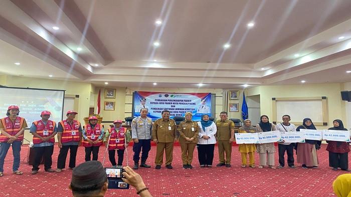 FOTO BERSAMA -- Wali Kota Pangkalpinang Prof. Saparudin bersama Wakil Wali Kota Dessy Ayutrisna, jajaran OPD, BPJS Ketenagakerjaan, serta perwakilan juru parkir dan keluarga penerima santunan berfoto bersama usai penyerahan atribut parkir dan santunan jaminan kematian bagi keluarga juru parkir di Balai Betason Kantor Wali Kota Pangkalpinang, Senin (22/12/2025).