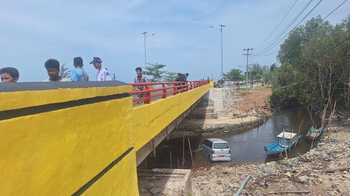 MOBIL TERJUN -- Kondisi kendaraan mini bus dengan plat nomor BN 1691 Z berwarna merah, yang terjun dari atas Jembatan yang menghubungkan Desa Guntung-Kelurahan Arung Dalam, Kecamatan Koba, pada Senin (9/3/2026).