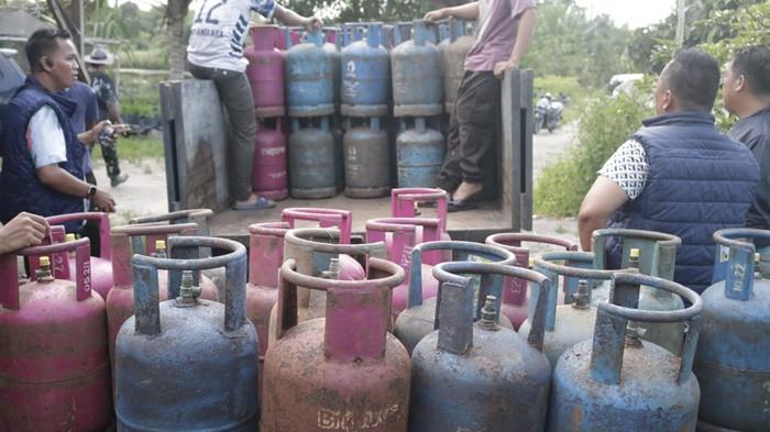 PENGOPLOSAN -- Anggota Ditreskrimsus Polda Babel, saat menggrebek lokasi pengoplosan gas LPG subsidi di Desa Jelutung, Kecamatan Namang, Kabupaten Bateng, Kamis (16/4/2026).