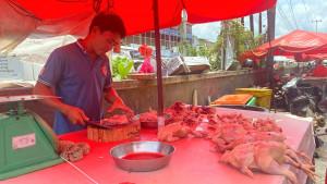 Pedagang-ayam-sedang-memotong-daging-ayam.jpg