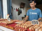 20240702-Pedagang-telur-ayam-Faisal-saat-merapikan-dagangan-telur.jpg
