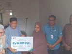 Penyerahan-simbolis-santunan-pada-ahli-waris-badan-Adhoc.jpg