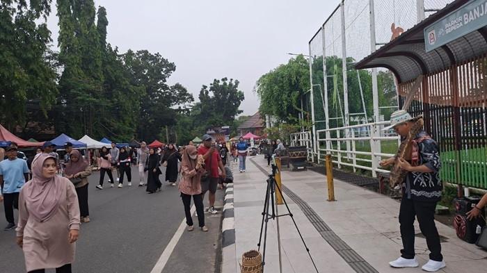 ALAT MUSIK - Arama memainkan alat musik tradisional Sape yang memikat pengunjung car free day Murjani, Banjarbaru saat akhir pekan, Minggu (10/8/2025).