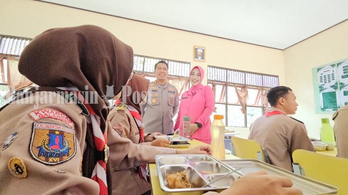 BERBINCANG DENGAN SISWA- Kapolres Balangan, AKBP Yulianor Abdi dan Ketua Cabang Bhayangkari Polres Balangan berinteraksi dengan siswa penerima manfaat MBG di SMAN 2 Paringin, Kamis (13/11/2025). (foto : isti rohayanti)