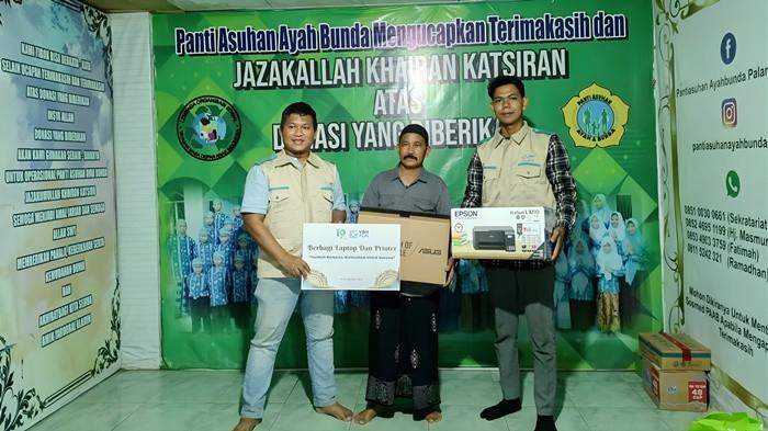 Khairullah, pengasuh Panti Asuhan Ayah Bunda Palangka Raya saat menerima Laptop