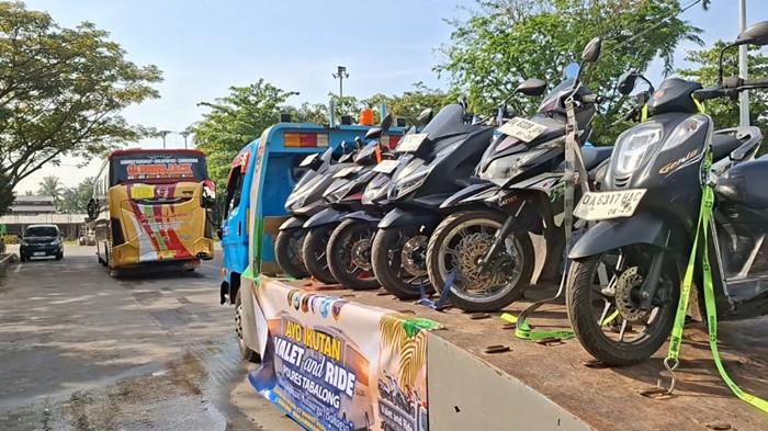 Mobil towing untuk layanan valet and ride membawa motor penumpang