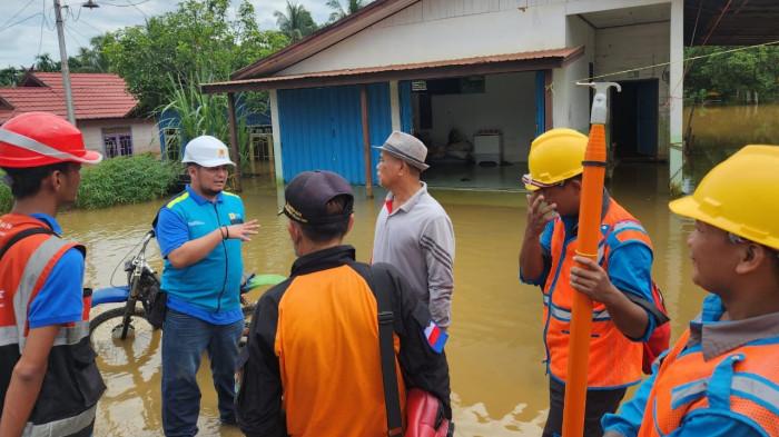 Petugas PLN saat memberikan edukasi pengamanan kelistrikan kepada masyarakat yang mengalami banjir.