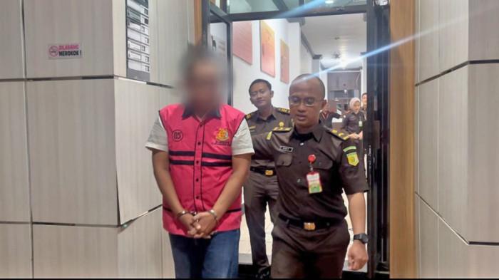 Tersangka SB saat digiring dari Kejari Tabalong untuk dilakukan penahanan selama 20 hari di Rumah Tahanan Negara IIB Tanjung, Senin (13/10/2025). tersangka adalah mantan pegawai bank BUMN.