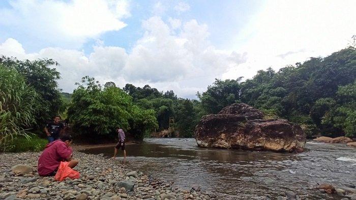 Pengunjung objek wisata Batu Ajung bersantai di pinggir Sungai Ajung.