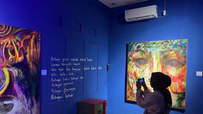 Nina, seorang pengunjung yang tampak antusias menikmati karya seni milik Badri Hurmansyah yang dipamerkan pada pameran tunggal miliknya.