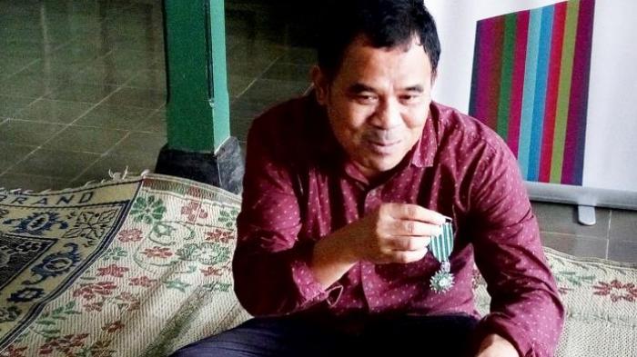 Sineas Indonesia Garin Nugroho saat menujukan emblem penghargaan Order Des Arts et Letters atau penghargaan bidang seni dan Sastra dari pemerintah Perancis.