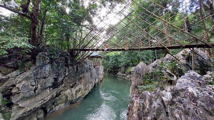 Pelancong wisata, berfoto di jembatan yang terdapat pada wisata alam pemandian watu badinding, Desa Liyu, Kecamatan Halong, Kabupaten Balangan, Selasa (4/10/2022).