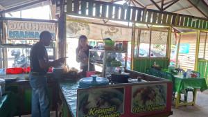 DHARMA-melayani-pembeli-di-warung-ketupatnya-di-Jalan-KH-Mansyur-Pelaihari.jpg